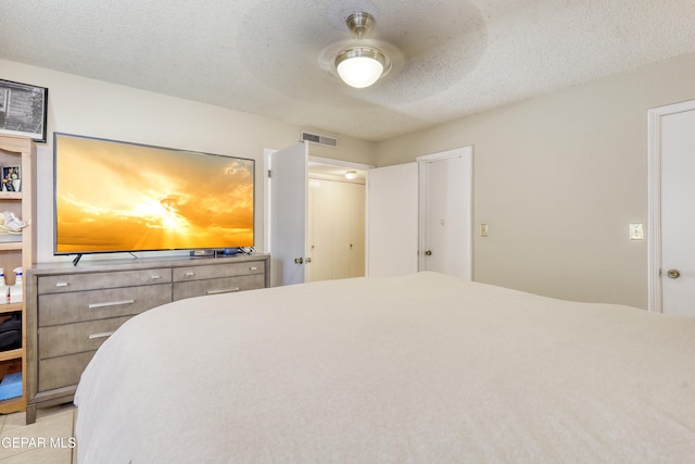 bedroom featuring ceiling fan and a textured ceiling