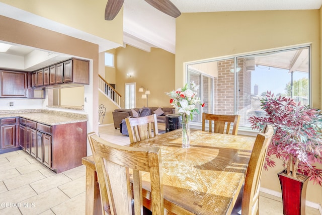 tiled dining space featuring a wealth of natural light and vaulted ceiling