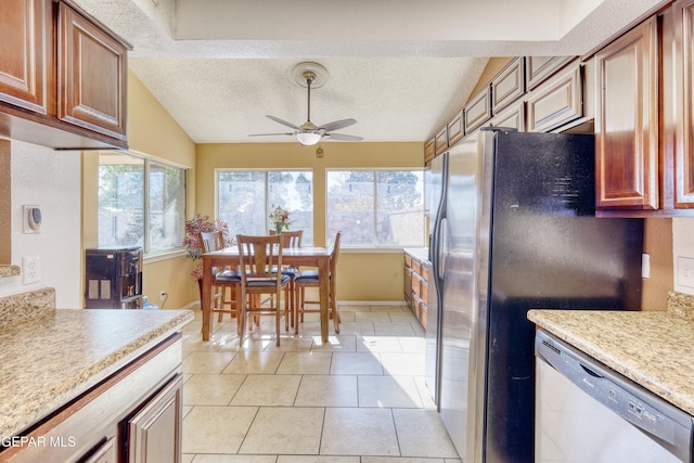 kitchen with ceiling fan, a textured ceiling, appliances with stainless steel finishes, and vaulted ceiling