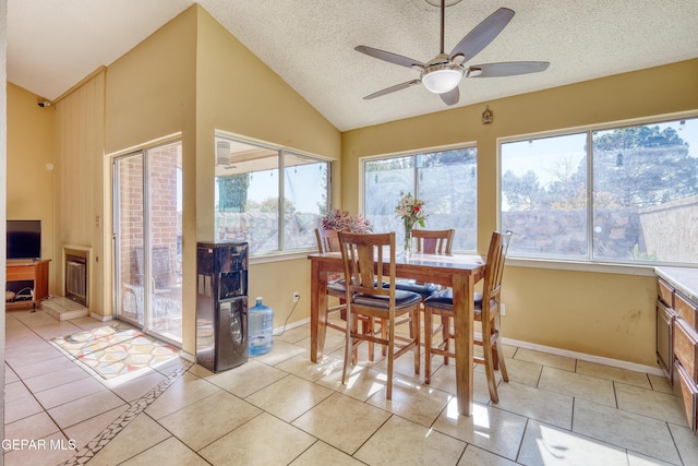 tiled dining space with a wealth of natural light, ceiling fan, and a textured ceiling