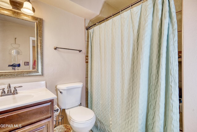 bathroom featuring vanity, toilet, and walk in shower