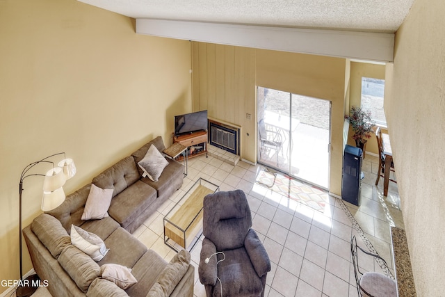 living room featuring light tile patterned flooring, lofted ceiling, and a textured ceiling