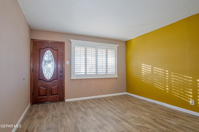 entrance foyer featuring light hardwood / wood-style floors and a textured ceiling