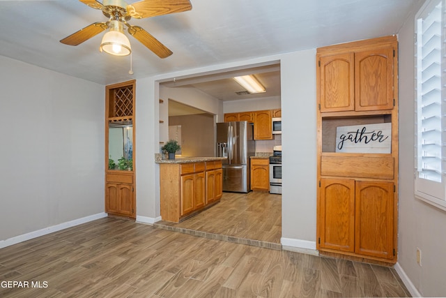 kitchen featuring appliances with stainless steel finishes, light hardwood / wood-style floors, tasteful backsplash, and ceiling fan