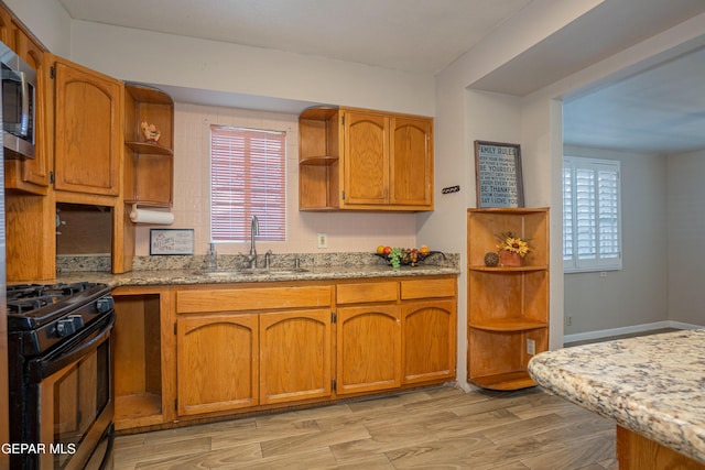 kitchen featuring gas stove, plenty of natural light, and light hardwood / wood-style flooring