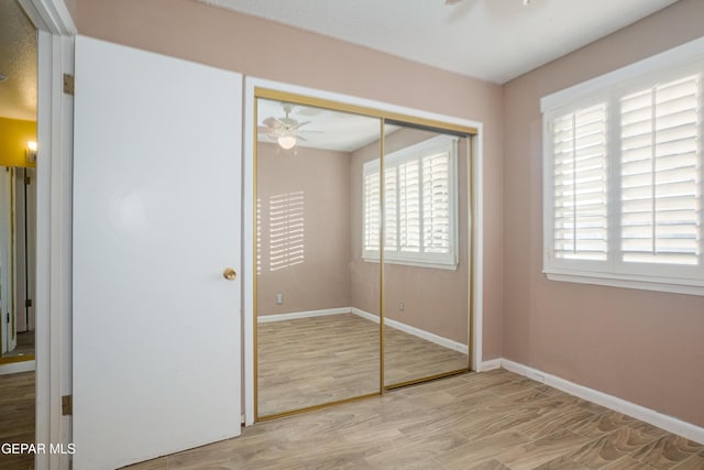 unfurnished bedroom with light wood-type flooring and a closet