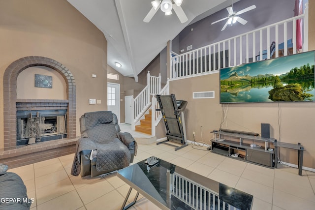 exercise room featuring tile patterned floors, ceiling fan, a fireplace, and high vaulted ceiling