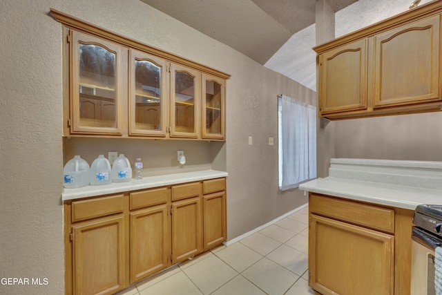 kitchen with light brown cabinets, lofted ceiling, black range, a textured ceiling, and light tile patterned flooring