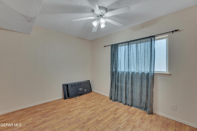 empty room featuring ceiling fan, a textured ceiling, and hardwood / wood-style flooring