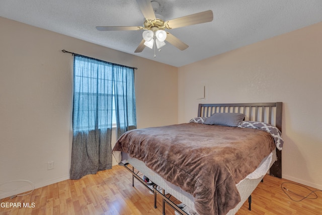 bedroom featuring hardwood / wood-style floors, ceiling fan, and a textured ceiling