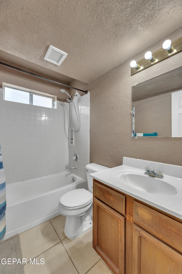 full bathroom featuring tile patterned floors, vanity, toilet, and a textured ceiling