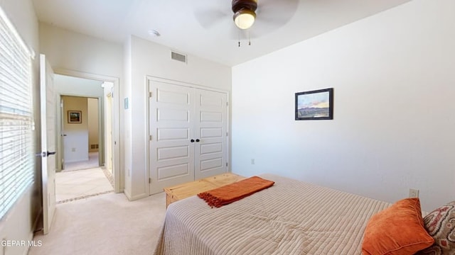 bedroom featuring ceiling fan, a closet, and light colored carpet