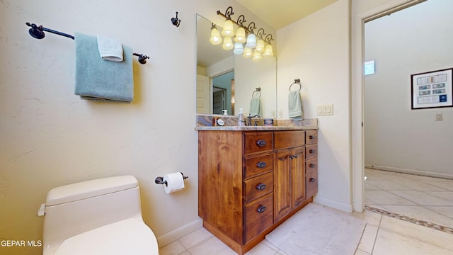 bathroom with toilet, vanity, and tile patterned floors