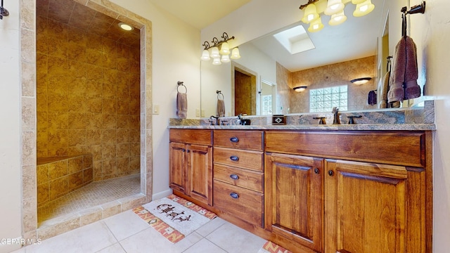 bathroom featuring tile patterned flooring, vanity, and tiled shower