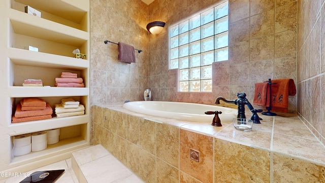 bathroom featuring tiled tub, tile patterned flooring, and tile walls