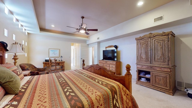 carpeted bedroom featuring a raised ceiling and ceiling fan