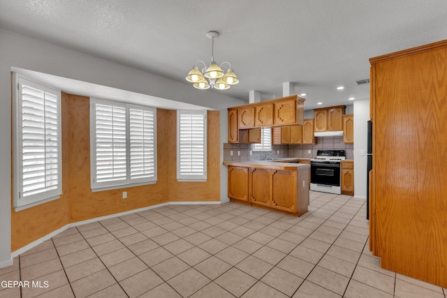 kitchen with tasteful backsplash, light tile patterned flooring, an inviting chandelier, hanging light fixtures, and white range oven