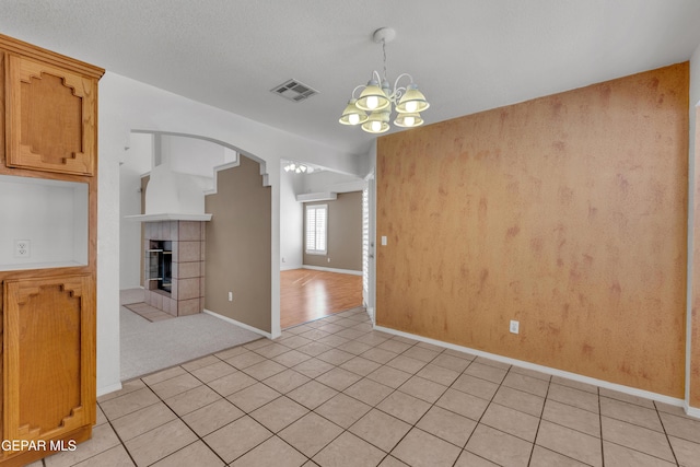 interior space with light tile patterned floors, a notable chandelier, and a fireplace