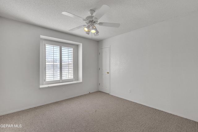 carpeted spare room with a textured ceiling and ceiling fan