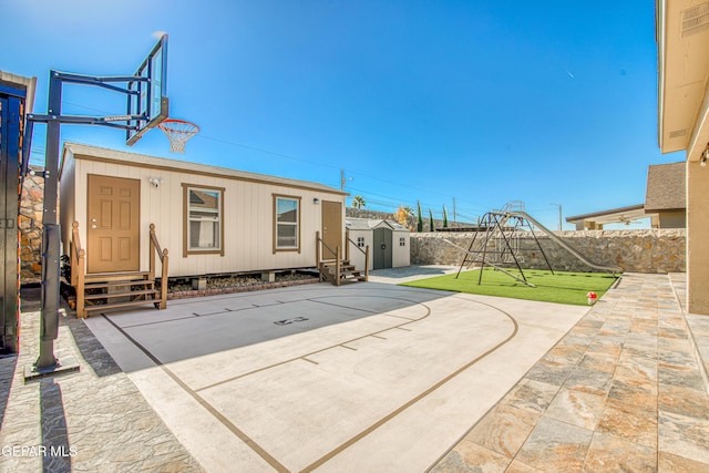 view of patio / terrace featuring basketball court and a storage shed