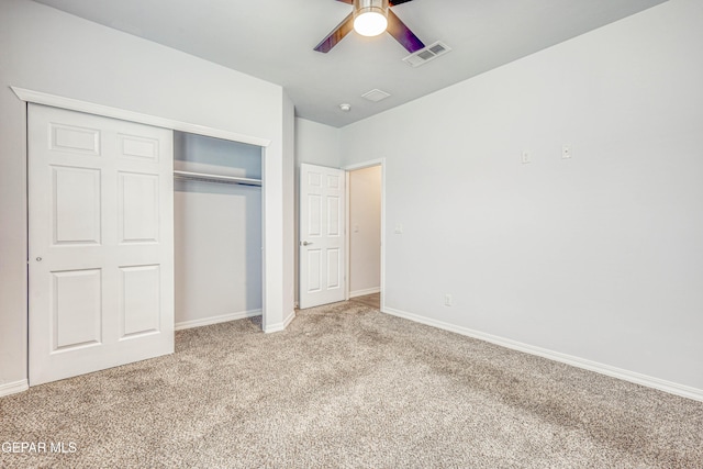 unfurnished bedroom with ceiling fan, a closet, and light carpet