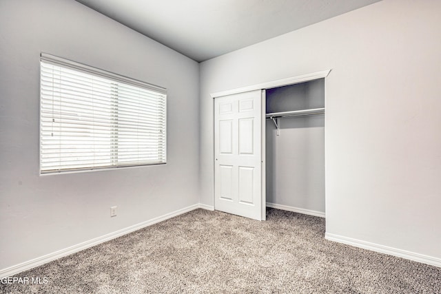 unfurnished bedroom featuring carpet flooring and a closet