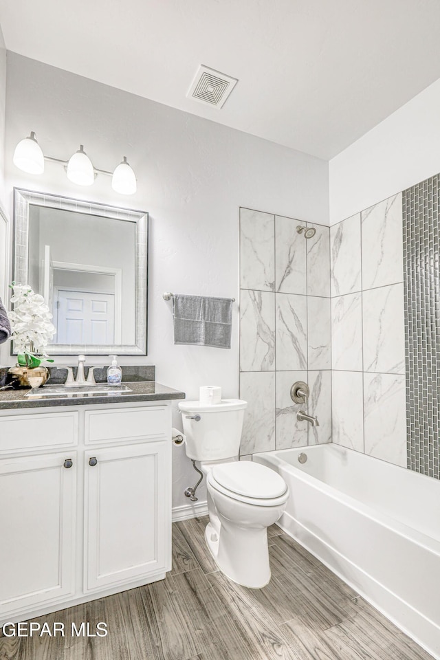 full bathroom with toilet, vanity, tiled shower / bath combo, and hardwood / wood-style flooring