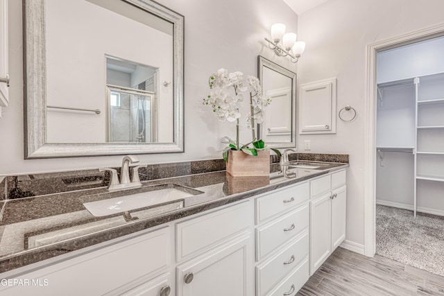 bathroom featuring hardwood / wood-style floors, vanity, and a shower with shower door