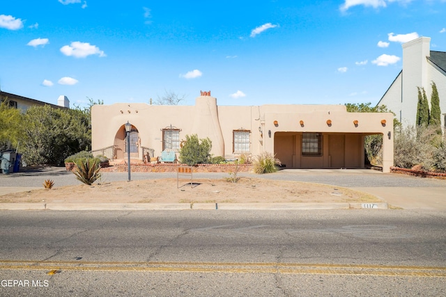 pueblo-style house with a carport