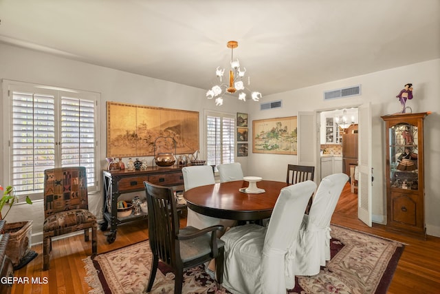 dining space with dark hardwood / wood-style flooring and a chandelier