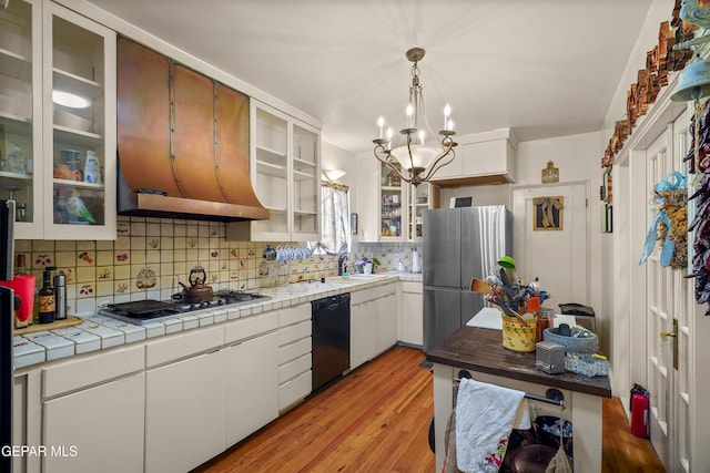 kitchen with stainless steel appliances, tasteful backsplash, tile countertops, light hardwood / wood-style floors, and white cabinets