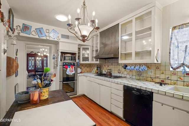1117 Kerbey Ave, El Paso, TX 79902 - kitchen with stainless steel appliances, a chandelier, decorative backsplash, white cabinets, and light wood-style flooring