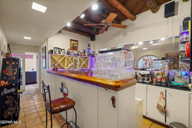 bar with butcher block counters, white cabinetry, ceiling fan, beamed ceiling, and wood ceiling