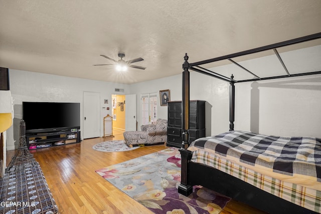 bedroom featuring hardwood / wood-style flooring, ceiling fan, and a textured ceiling