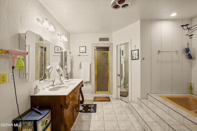 bathroom with vanity, shower with separate bathtub, a textured ceiling, and tile patterned floors