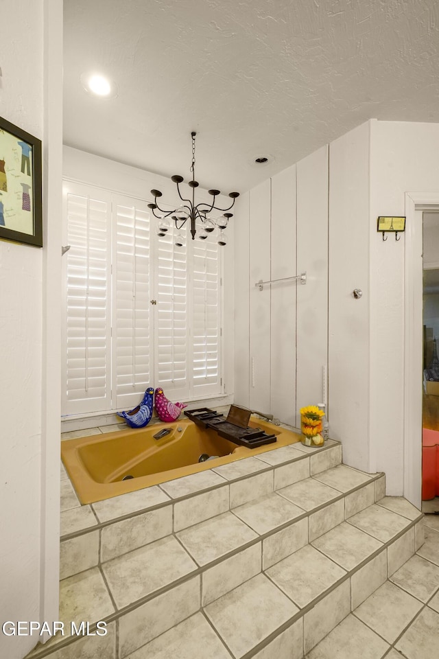 mudroom featuring light tile patterned floors, a textured ceiling, and a chandelier