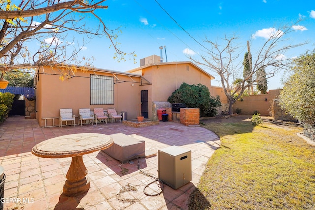 back of house featuring a yard, a patio, and exterior kitchen