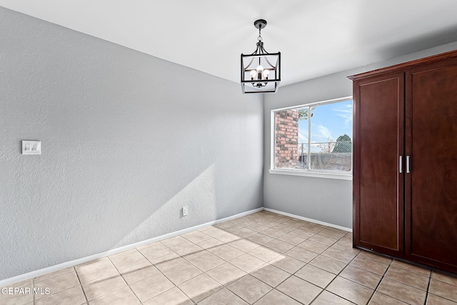 unfurnished dining area with a chandelier and light tile patterned floors