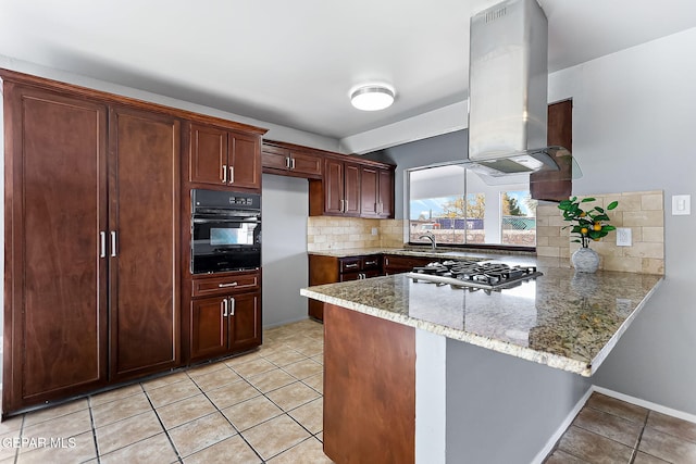 kitchen with decorative backsplash, light stone countertops, black oven, kitchen peninsula, and extractor fan