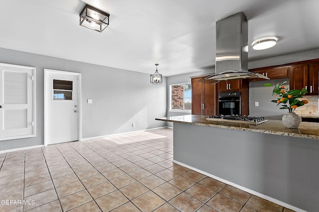 kitchen featuring appliances with stainless steel finishes, stone countertops, an inviting chandelier, and island range hood