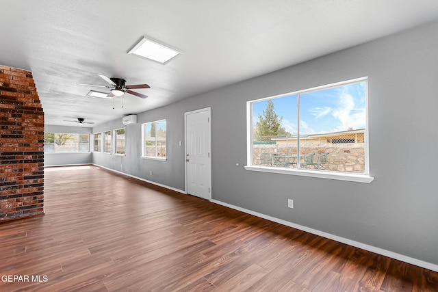 17001 Darrington Rd, Horizon City, TX 79928 - unfurnished living room with a wall mounted AC, ceiling fan, and wood finished floors