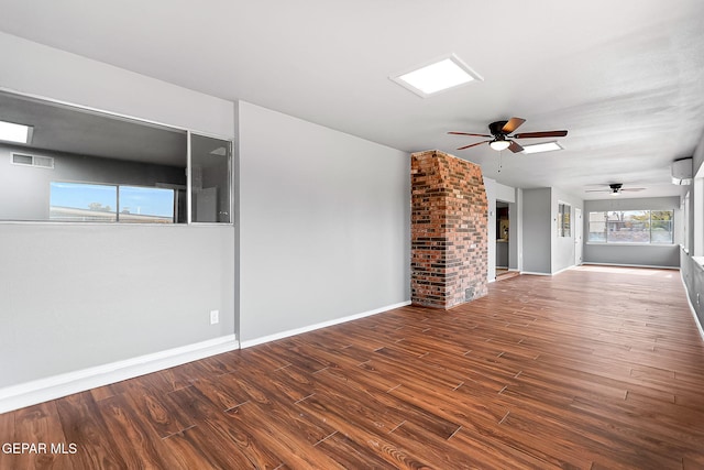 unfurnished living room featuring a wall mounted AC, dark hardwood / wood-style flooring, and ceiling fan