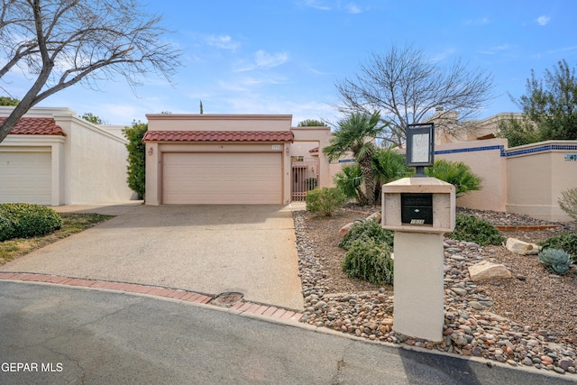 view of front of house with a garage, a tile roof, fence, and stucco siding