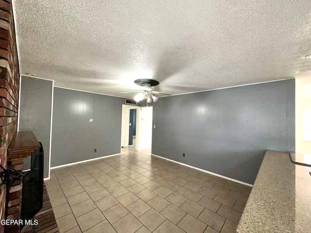 tiled spare room featuring ceiling fan and a textured ceiling