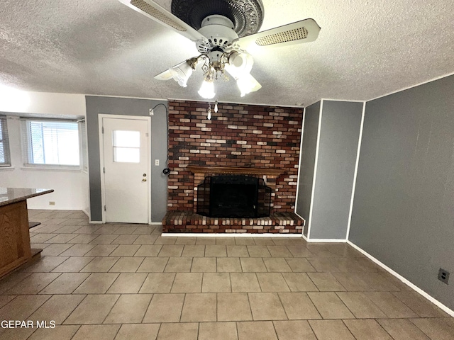 unfurnished living room featuring ceiling fan, a fireplace, and a textured ceiling