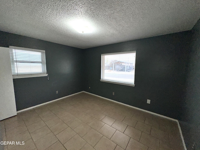 unfurnished room featuring a textured ceiling