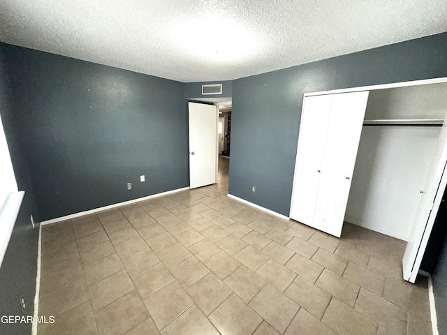 unfurnished bedroom with a textured ceiling and a closet