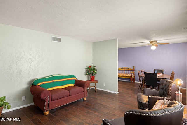 living room with a textured ceiling, dark hardwood / wood-style floors, and ceiling fan