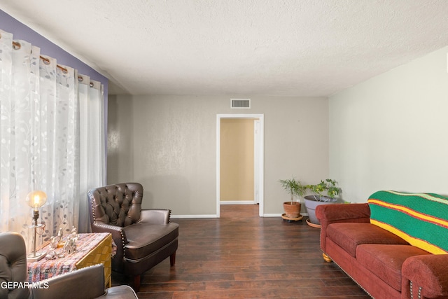 living room with dark wood-type flooring and a textured ceiling