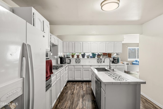 kitchen with white cabinetry, sink, tile counters, dark wood-type flooring, and stainless steel appliances